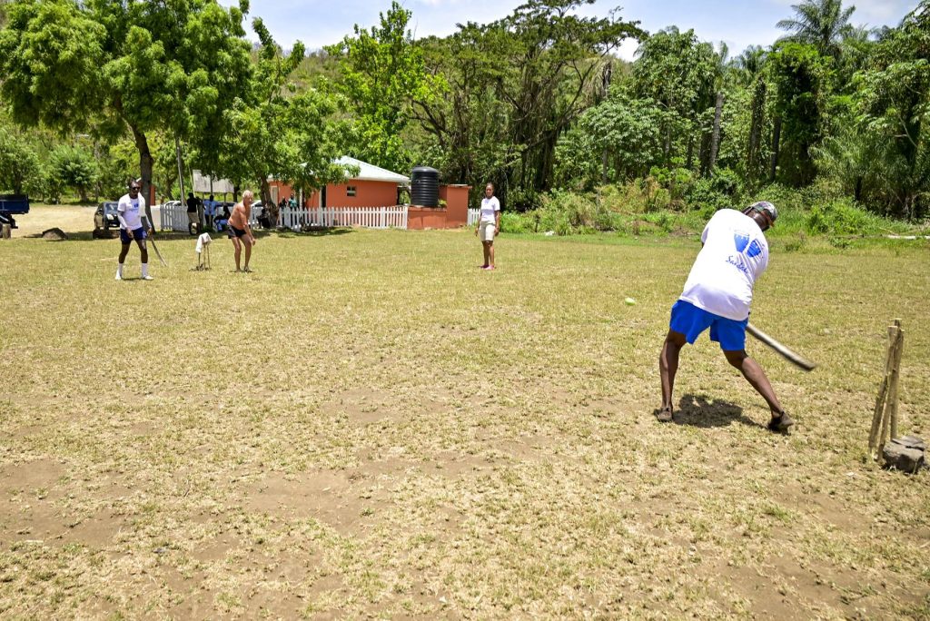 Guests and team members engage in a friendly game of cricket during the Black Sand Beach Day Lyme, offering an authentic taste of one of Saint Vincent and the Grenadines’ most beloved pastimes